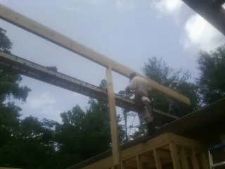 Carpenter setting a ridge beam over a new addition frame — Ice Dam Removal by Roofing Brothers in Fullerton